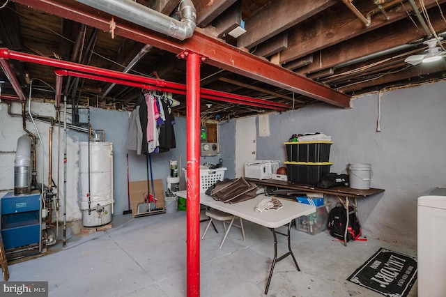 unfinished below grade area featuring a heating unit, washer / clothes dryer, and gas water heater