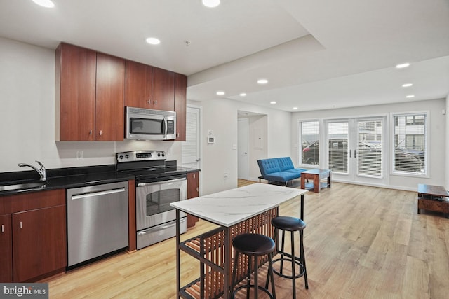 kitchen featuring appliances with stainless steel finishes, light hardwood / wood-style floors, and sink