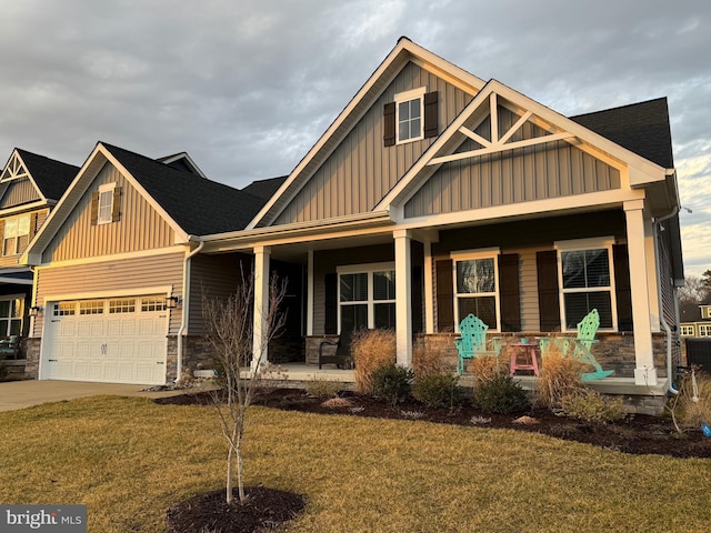 craftsman-style home with a porch, a garage, and a front yard