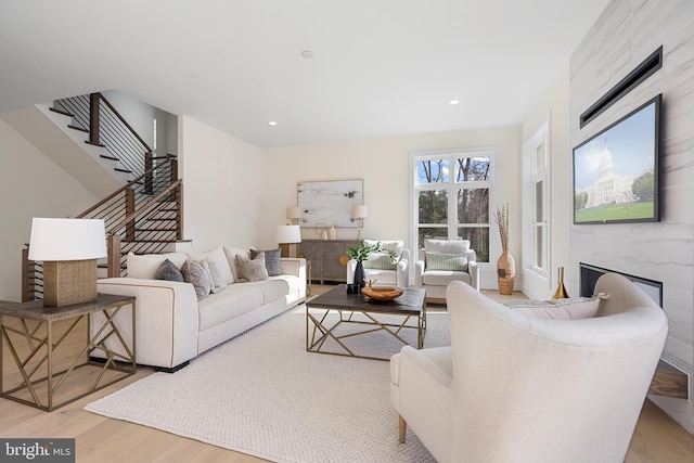 living room featuring recessed lighting, stairway, a fireplace, and wood finished floors