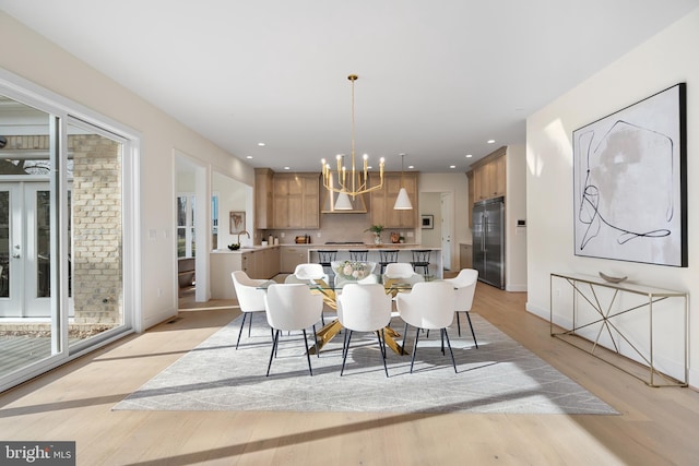 dining space with light wood finished floors, baseboards, a notable chandelier, and recessed lighting