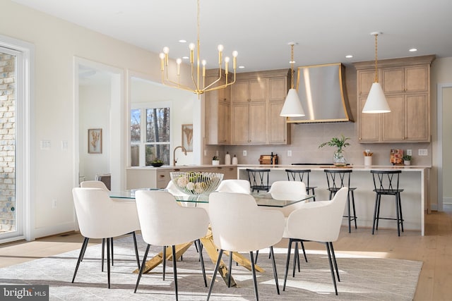 dining space featuring baseboards, an inviting chandelier, recessed lighting, and light wood-type flooring