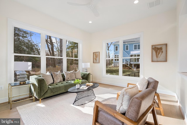 living room featuring visible vents, baseboards, recessed lighting, a ceiling fan, and light wood-type flooring