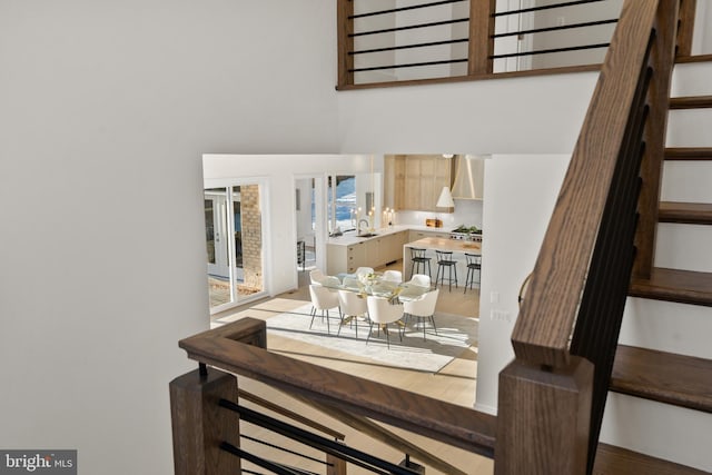 dining area with a towering ceiling and stairs