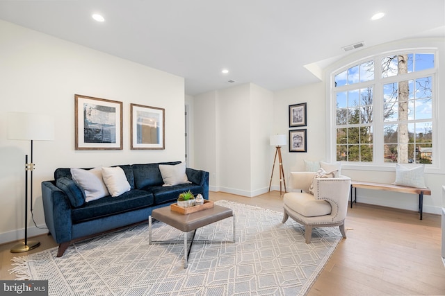 living room with baseboards, a healthy amount of sunlight, recessed lighting, and light wood finished floors