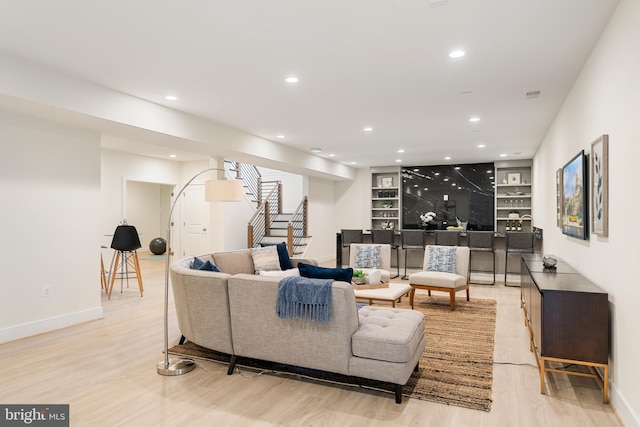 living room featuring stairs, built in features, a dry bar, and recessed lighting