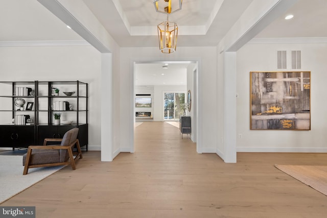 foyer entrance featuring wood finished floors, baseboards, and visible vents