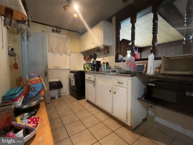 kitchen with white cabinetry, sink, light tile patterned flooring, and black appliances