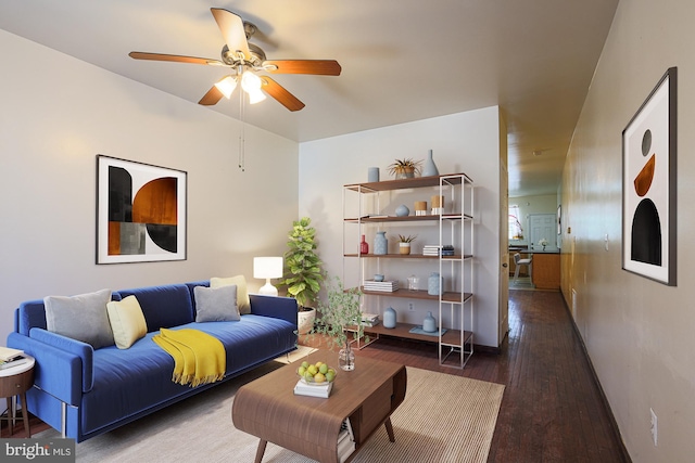 living room with dark wood-type flooring and ceiling fan