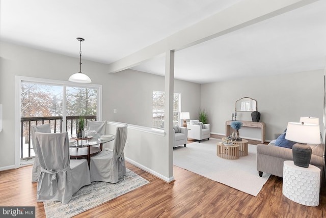 dining room featuring beamed ceiling and wood-type flooring