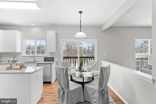 dining room with plenty of natural light, sink, and light wood-type flooring