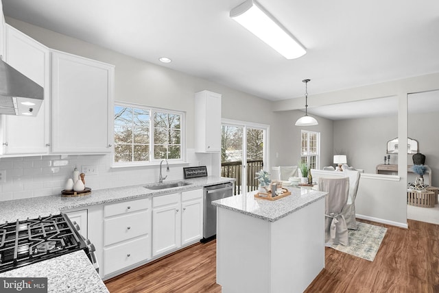 kitchen featuring sink, hanging light fixtures, white cabinets, and appliances with stainless steel finishes