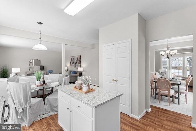 kitchen with dark hardwood / wood-style flooring, hanging light fixtures, a center island, and white cabinets