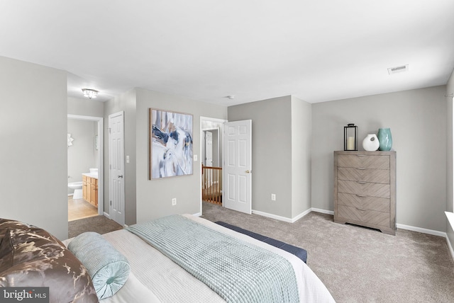 carpeted bedroom featuring ensuite bath