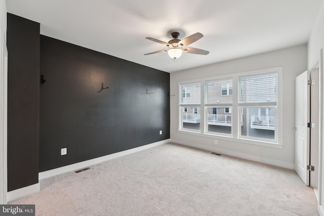 spare room with light colored carpet and ceiling fan