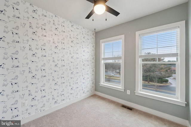 empty room with ceiling fan and carpet