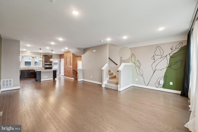 unfurnished living room featuring sink and dark wood-type flooring