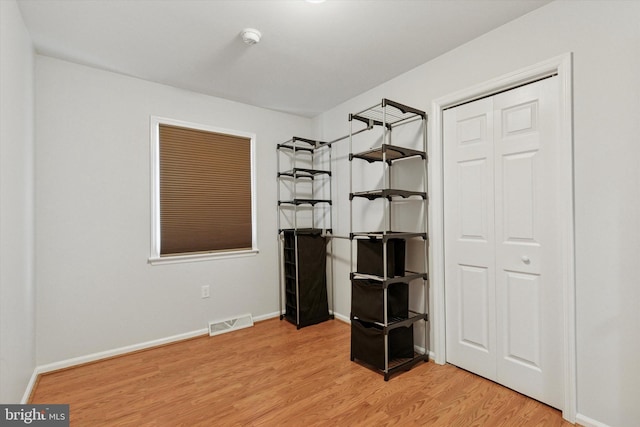 unfurnished bedroom with light wood-style flooring, visible vents, and baseboards