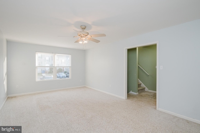 spare room with stairs, ceiling fan, and baseboards