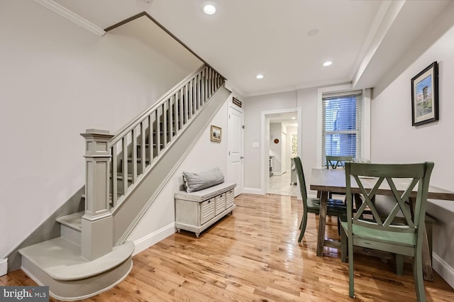 dining room with crown molding and light hardwood / wood-style floors