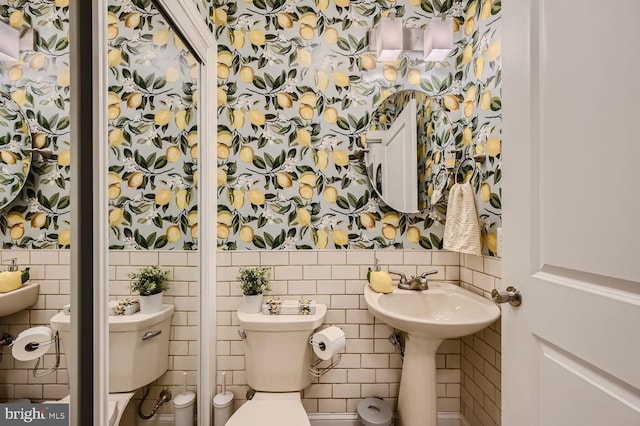 bathroom with toilet and tile walls