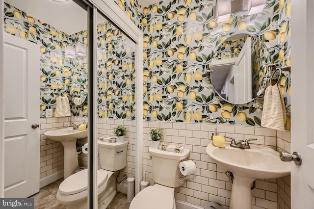 bathroom featuring tile walls and toilet