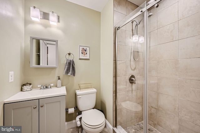 bathroom featuring vanity, a shower with shower door, and toilet