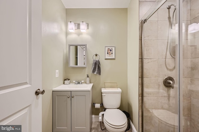 bathroom with vanity, a shower with shower door, and toilet