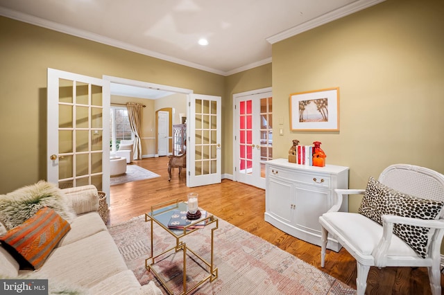 sitting room featuring arched walkways, recessed lighting, light wood-style floors, french doors, and crown molding