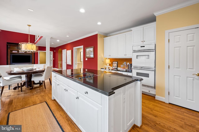 kitchen featuring white double oven, black electric stovetop, dark countertops, white cabinetry, and light wood-type flooring