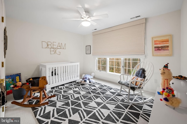 carpeted bedroom featuring a ceiling fan and visible vents