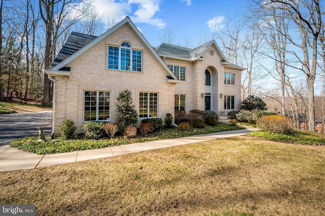 view of front of property with brick siding and a front lawn