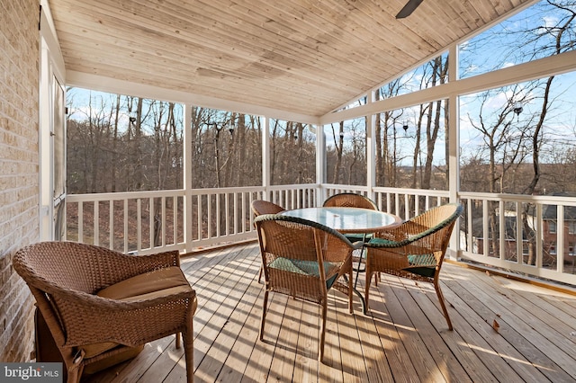 sunroom / solarium featuring lofted ceiling, wooden ceiling, and plenty of natural light