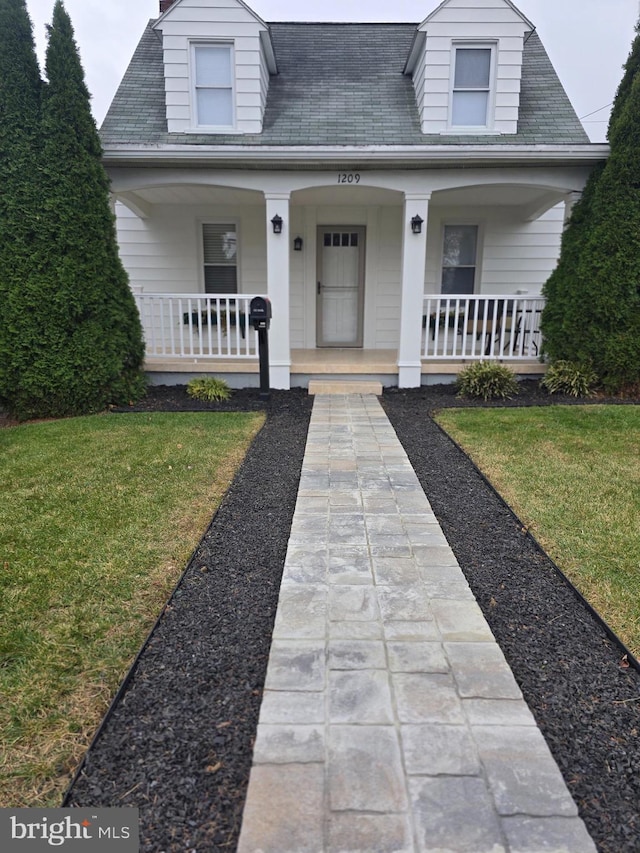 view of front of house with a front yard and a porch