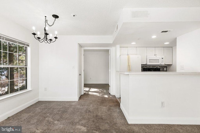 unfurnished dining area featuring baseboards, visible vents, dark colored carpet, and a chandelier