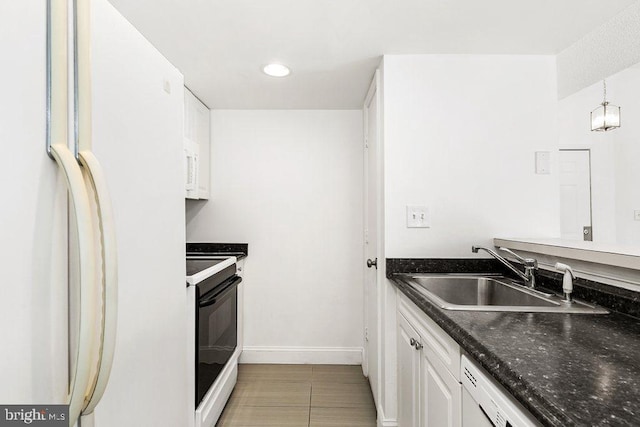 kitchen with pendant lighting, white cabinetry, a sink, white appliances, and baseboards