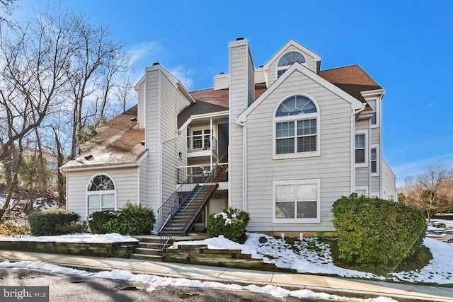 view of front of home featuring a chimney and stairway