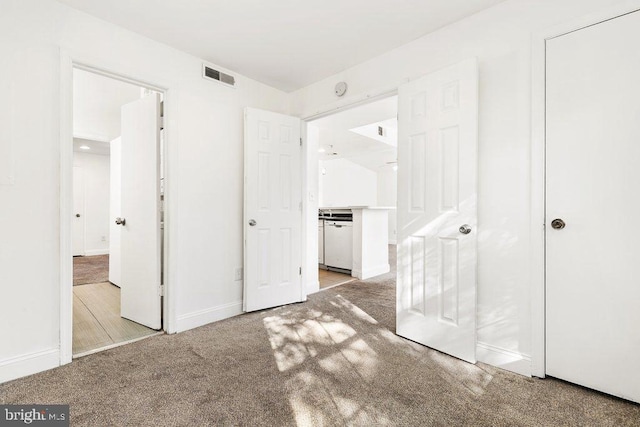 unfurnished bedroom with light carpet, visible vents, and baseboards