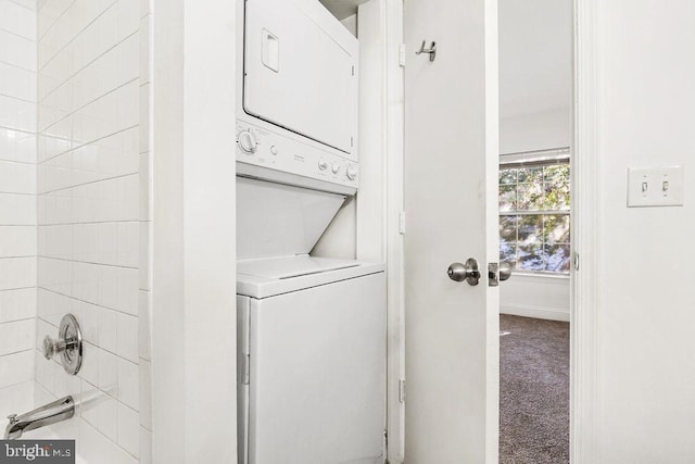 washroom with stacked washer / dryer, carpet flooring, and baseboards