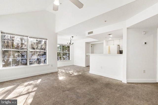 unfurnished living room with visible vents, baseboards, lofted ceiling, carpet, and ceiling fan with notable chandelier