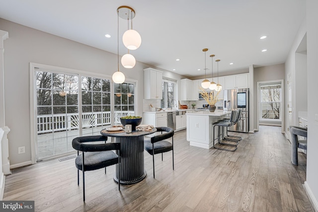 dining room with a healthy amount of sunlight and light wood-type flooring