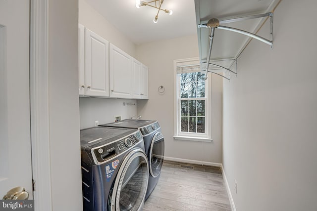 washroom featuring cabinets, washer and dryer, and light wood-type flooring