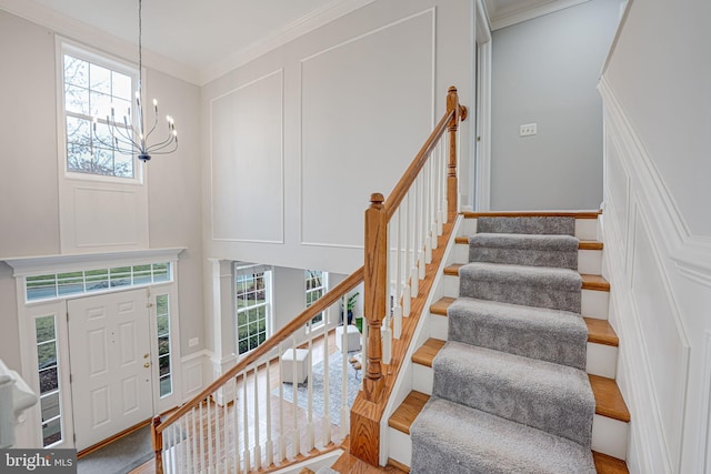 foyer with a notable chandelier and ornamental molding