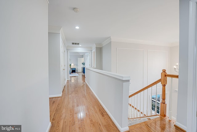 hall featuring crown molding and light hardwood / wood-style floors