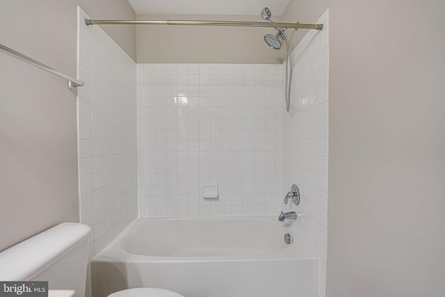 bathroom featuring tiled shower / bath and toilet