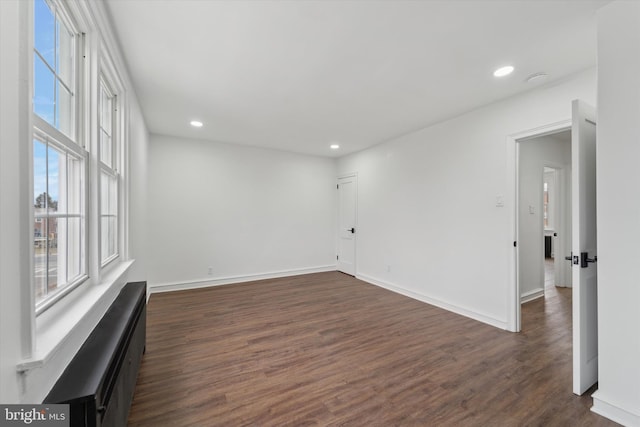 spare room featuring dark hardwood / wood-style flooring and a wealth of natural light