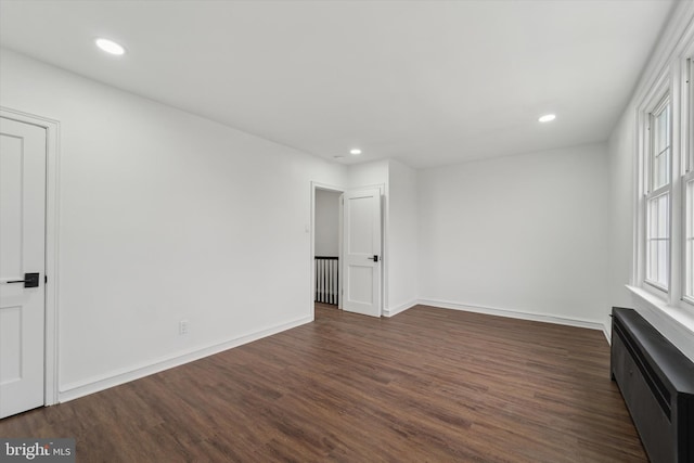 unfurnished room with dark wood-type flooring