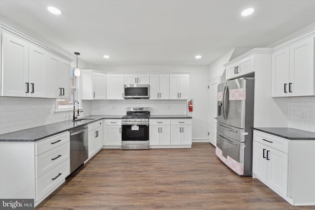 kitchen with pendant lighting, white cabinetry, dark hardwood / wood-style flooring, and appliances with stainless steel finishes