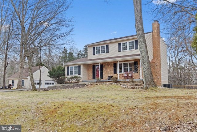 traditional-style home featuring covered porch, central AC, brick siding, a chimney, and a front yard