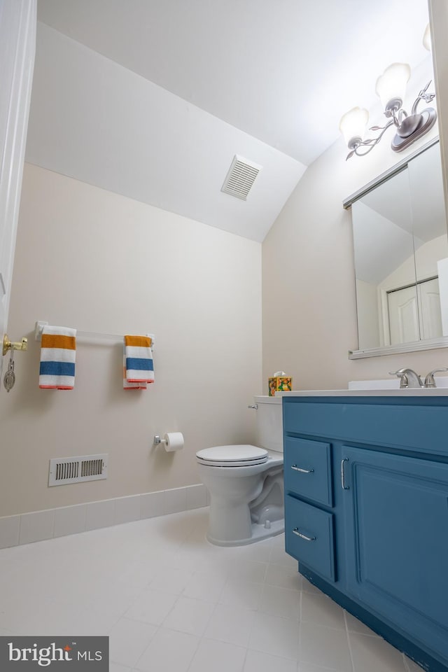 bathroom with vanity, lofted ceiling, and toilet